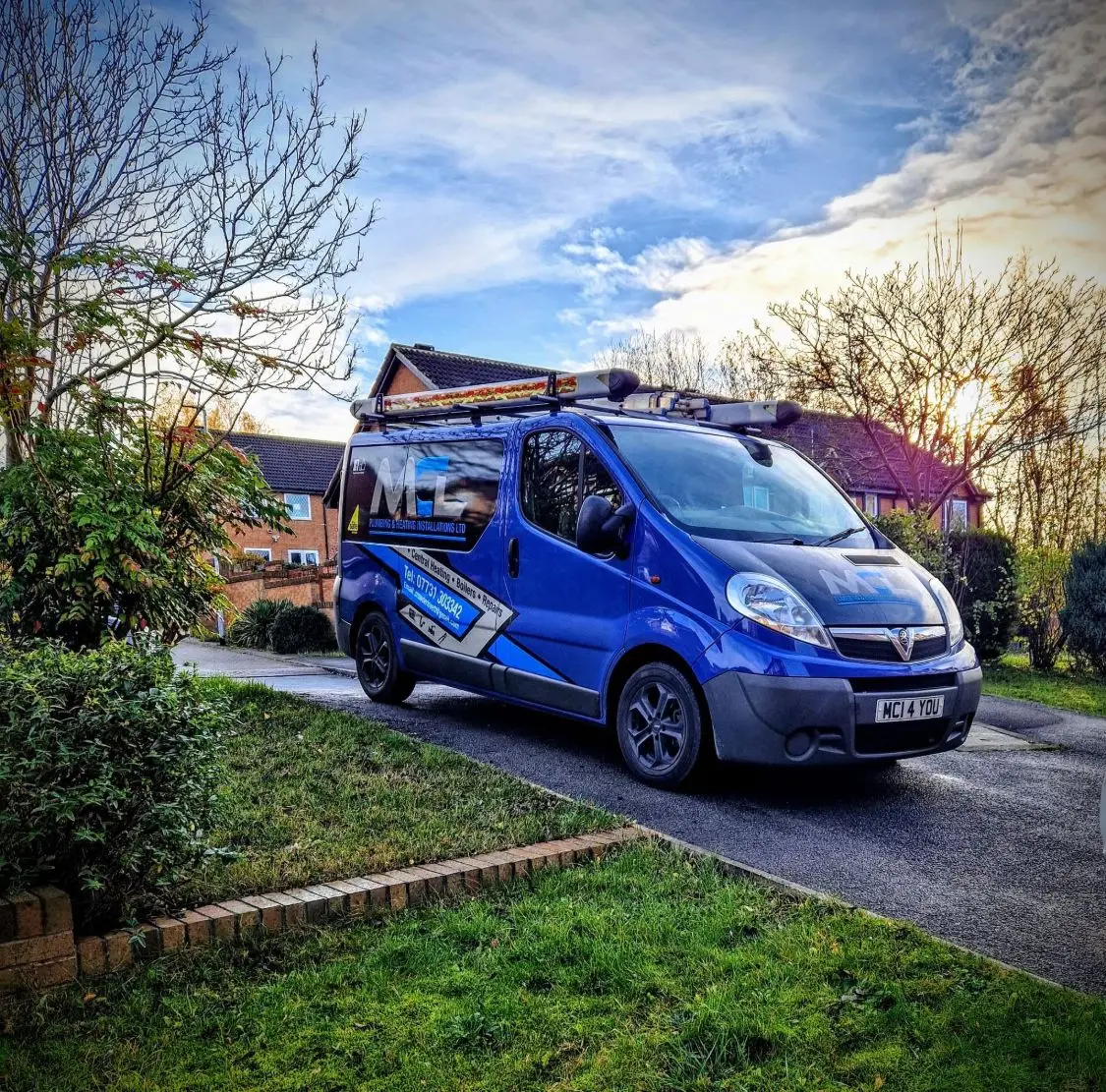 The MCL Plumbing & Heating branded van parked on a driveway at sunset, with a warm sky behind it