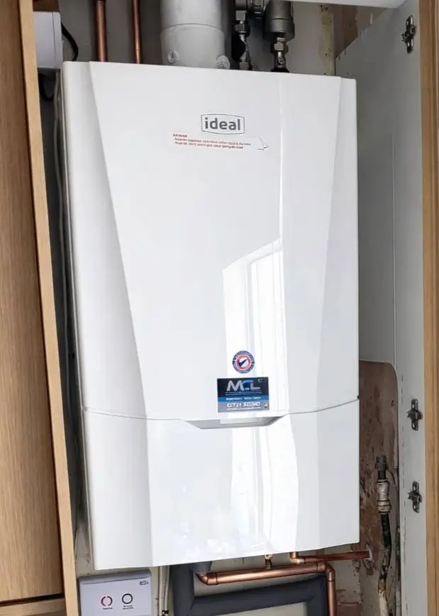 A newly fitted white Ideal combi boiler with an MCL Plumbing & Heating branded sticker on the front panel